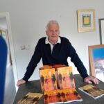 photo of author michael ross with table display of several quiet the waves books