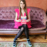 photo of author patricia leavy sitting on a couch while holding her book, after the red carpet